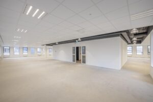 Spacious empty office space at Hiridostraat 3 with large windows and white walls.